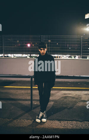 Man leaning against railing waiting, Milan, Italy Stock Photo