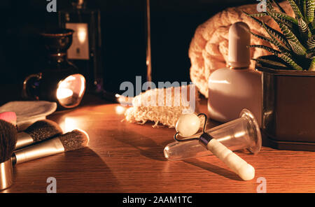 Luxurious jade massager and facial massage jar. Composition of massager and massage jar from aging on the women's table. The concept of natural skin c Stock Photo