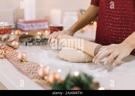 Woman's hands rolling gingerbread dough on countertop Stock Photo