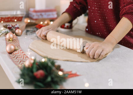 Female hands rolling cookie dough with wooden rolling pin Stock Photo