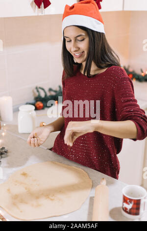 Side view of woman preparing roll out dough for cutting Stock Photo