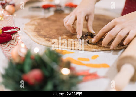 Lady shaping CHristmas man biscuits in cookie dough. Stock Photo