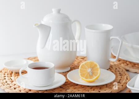 White ceramic tableware, fibre braided round placemat and cutlery set on white background. Stock Photo