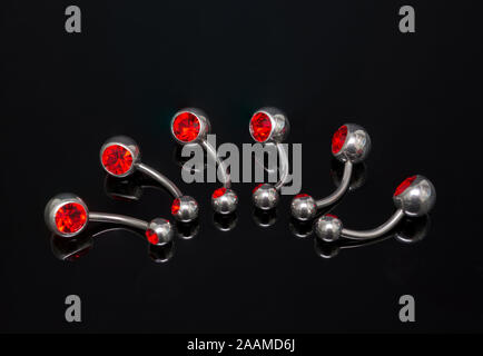 Set of belly piercing on black background. Body jewelry. Stock Photo