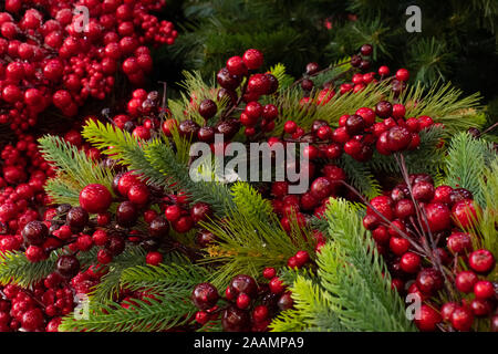 Holly berries and Christmas tree. New Year Christmas decoration, backdrop background. Artificial Christmas tree and decorative red berries of holly Stock Photo