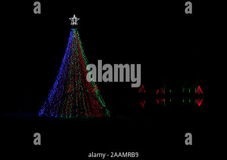 Giant outdoor Christmas tree, multicolored lights, lake reflections, white star on top, Meadowlark Gardens, Winter Walk of Lights. Sharp on download. Stock Photo