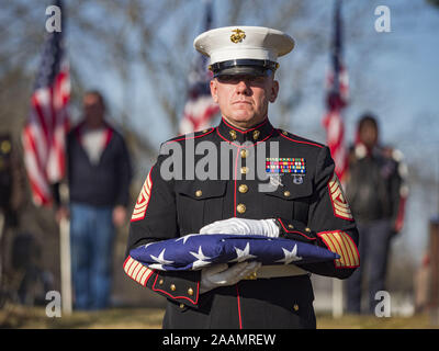 Des Moines, Iowa, USA. 22nd Nov, 2019. US Marine Corps First Sgt. MICHAEL SODERGREN holds a folded United States flag during the reinterment service of US Marine Corps Reserve Private Channing Whitaker in Glendale Cemetery. The flag was presented to Whitaker's family. Whitaker died in the Battle of Tarawa on Nov. 22, 1943. He was buried on Betio Island, in the Gilbert Islands, and his remains were recovered in March 2019. He was identified by a DNA match with surviving family members in Iowa. Credit: ZUMA Press, Inc./Alamy Live News Stock Photo