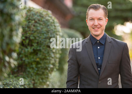 Happy young handsome businessman in suit smiling outdoors Stock Photo