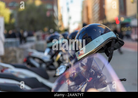 Police helmet with American flag sticker hanging off a police scooter on a New York City street Stock Photo