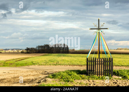 Late autumn. A cross standing at the crossroads, among fields and meadows.  Close-up. Old Christian tradition. Podlasie, Poland. Stock Photo