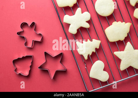 https://l450v.alamy.com/450v/2aanb5a/flat-lay-of-christmas-cookies-on-oven-grate-and-cookie-cutters-against-red-background-minimal-creative-holiday-and-food-concept-2aanb5a.jpg