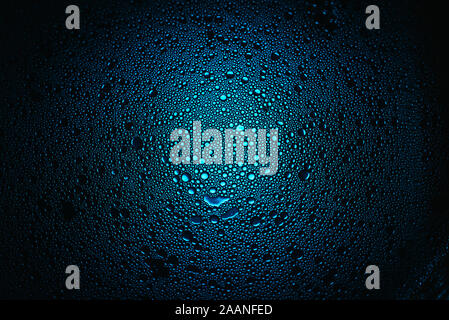 mixture of water and olive oil forming droplets with blue backlight Stock Photo