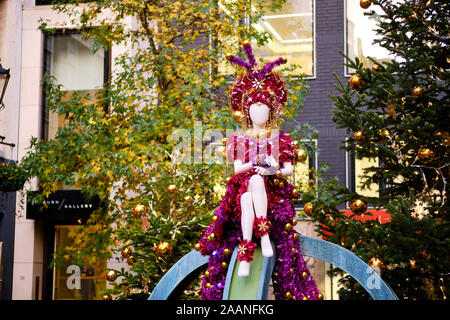 St Christopher's Place Christmas decoration of a female mannequin dressed in colourful garland Stock Photo