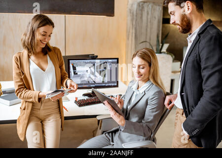 Strictly dressed office employees working with digital tablet and computers at the architectural bureau. Concept of an architectural business and digital designing Stock Photo
