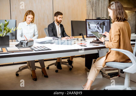 Creative office employees making interior design on the computers, sitting at the modern office of architectural firm. Concept of 3d modeling and digital Interior designing Stock Photo