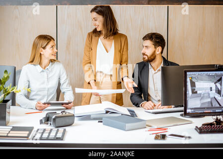 Small group of creative office employees working together on some architectural project in the modern office. Concept of an architectural business and creative work Stock Photo