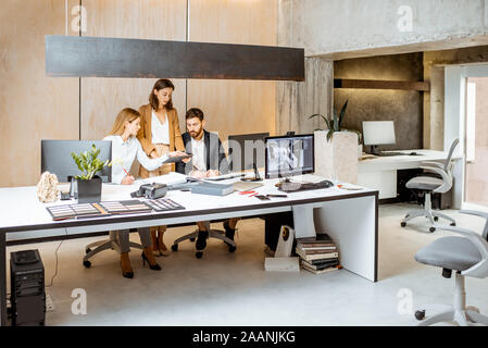 Small group of creative office employees working together on some architectural project in the modern office. Concept of an architectural business and creative work Stock Photo