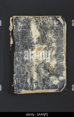 Top view of very old, aged and torn black, blue and brown book on black background Stock Photo