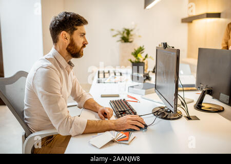 Creative office employee making interior design, 3d modeling on the computer while sitting at the modern office of architectural firm Stock Photo