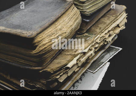Pile of old, aged, dusty and dark books on black background with copy space Stock Photo