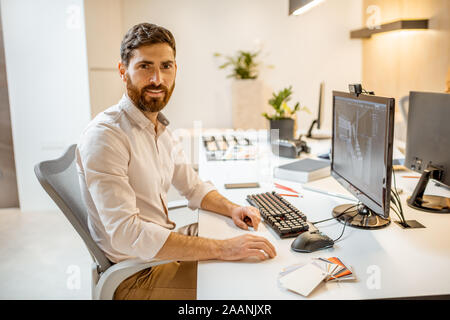 Portrait of creative office employee making interior design, 3d modeling on the computer while sitting at the modern office of architectural firm Stock Photo