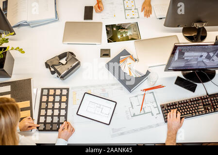 Creative workplace of designers or architects, designing interior. Top view on the table with various architectural drawings, computers and office supplies Stock Photo