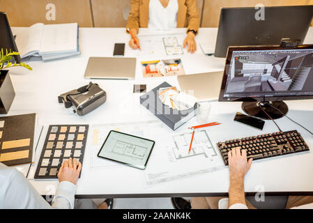 Creative workplace of designers or architects, designing interior. Top view on the table with various architectural drawings, computers and office supplies Stock Photo