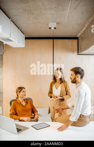 Office employees having some informal conversation at the workplace in the office Stock Photo
