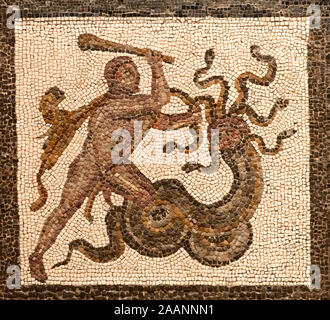 roman mosaic representing a god hercules fighting with a moster, figure in brown color on a white small tiles background Stock Photo