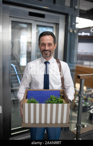 Businessman wearing formal clothing holding box with personal things Stock Photo