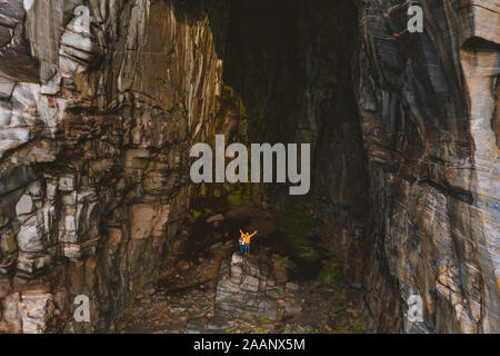 Travel family in cave vacations outdoor active lifestyle in Norway mountains aerial view grotto Kirkhelleren hole in rock Stock Photo