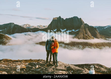 Family couple kissing on mountain top traveling with baby hiking together in Norway man and woman healthy lifestyle active vacations outdoor feelings Stock Photo