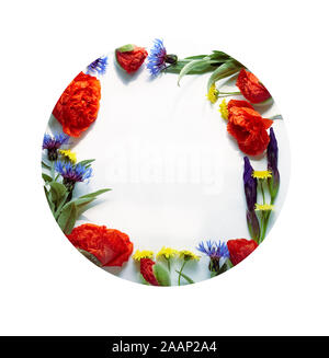 Spring floral composition from poppies, cornflowers, irises, and wild flowers with green leaves, hello spring writing  inside of flowering frame, flat Stock Photo
