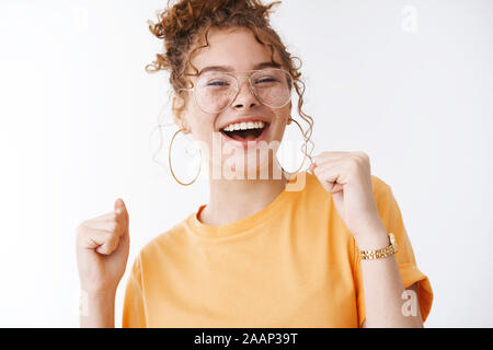 Carefree stylish good-looking redhead ginger girl 20s freckled cheeks laughing out loud happily dancing raise clenched fists moving rhythm music Stock Photo