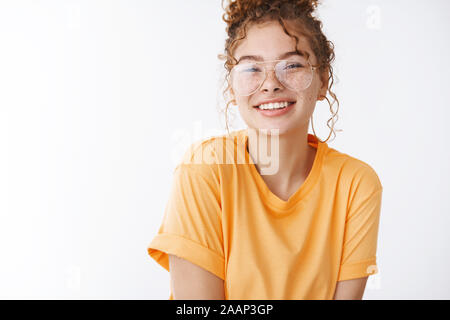 Close-up charming teenage redhead girl wearing glasses messy curly bun smiling laughing friendly expressing happiness joy carefree emotions, standing Stock Photo