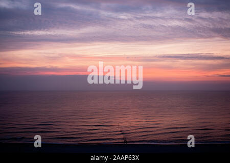 Farbenspiele auf Wolken und Meer nach Sonnenuntergang am Strand bei Wenningstedt auf Sylt Stock Photo