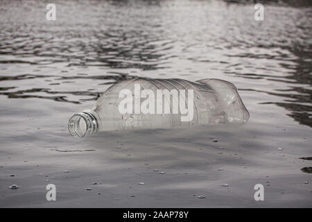 Empty plastic bottle floating in water. Pollution concept. Close up image. Stock Photo