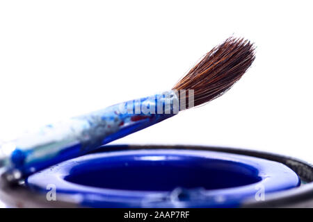 Tins of model paint and a fine paint brush isolated on a white background Stock Photo