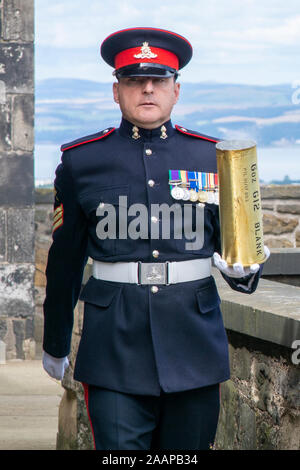 District Gunner carrying blank shell after firing the One O'clock gun, Edinburgh castle Stock Photo