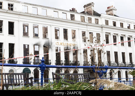 Eastbourne, UK. 23rd November, 2019.  East Sussex Fire and Rescue Service remain at the scene of yesterdays devastating fire which gutted  the Claremont Hotel, Eastbourne. The seafront including the towns famous pier, itself severely damaged by fire in 2014 remain closed to traffic and pedestrians whilst the clearing up operation continues. Credit: Alan Fraser/Alamy Live News Stock Photo