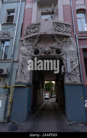 Unique sculptures on the facade of the building. Two men are holding a balcony. Vertical frame. Stock Photo