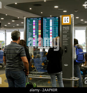 Flight check-in information board showing cancelled and delayed flights in red. Cancelado, demorado. Spanish language. Stock Photo