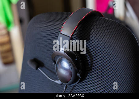 black headset on backrest of empty computer chair with air mesh ...