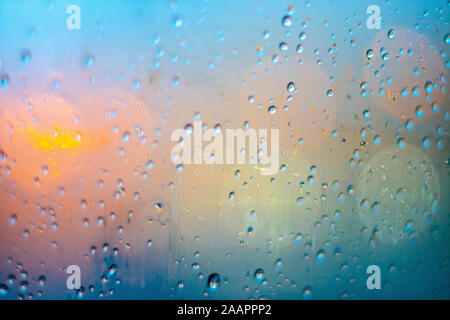Closeup on waterdrops in glass with colorful bokeh on the background Stock Photo
