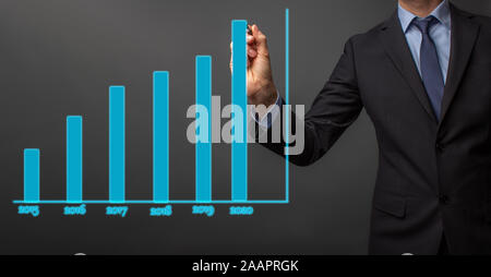 business man in suit is drawing a growth rate - anual growth rate - business decrease or inrease Stock Photo