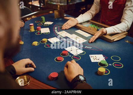 Hands of players and croupiers in the game cards. Stock Photo