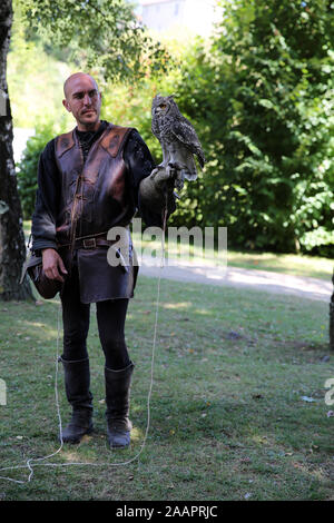 A male falconer with an owl, Chauvigny, France Stock Photo