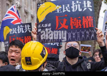 London, UK. 23 November 2019. Hundreds of Black-clad protesters protest at a rally at the gates of Downing St where they took in a letter urging the Prime Minister to act over China's breaches of the Sino-British Joint Declaration. They called attention to Hong Kong's humanitarian crisis, widespread injustices and erosion of autonomy and called for the Hong Kong protesters 5 demands to be met. Peter Marshall/Alamy Live News Stock Photo