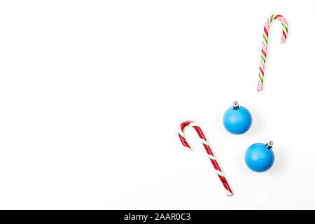 Minimal Christmas background. Two candy canes and two blue Xmas decoration bauble balls on white background. Top view Stock Photo