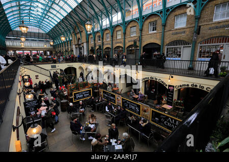 Christmas lights and busy Christmas market stalls inside Covent Garden, City of Westminster, London, England, UK Stock Photo